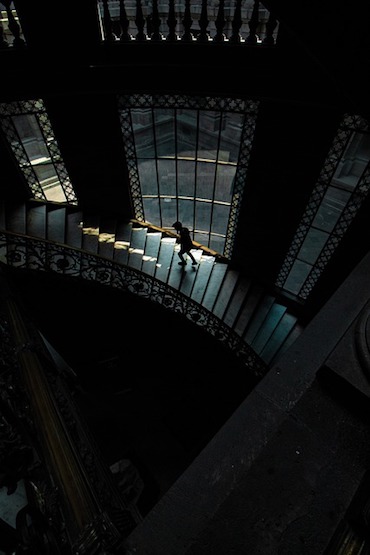 foto di persona che sale scale buie di un museo